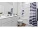 Well-lit bathroom featuring a tub/shower combo with a striped shower curtain, a toilet, and a vanity with countertop at 137 Bastian Rd, Mcdonough, GA 30252