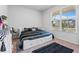Bright bedroom with a bed featuring drawer storage and a view of the neighborhood through a large window at 137 Bastian Rd, Mcdonough, GA 30252