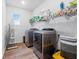 Functional laundry room with stainless steel appliances, overhead storage, and durable flooring at 137 Bastian Rd, Mcdonough, GA 30252