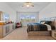 Spacious main bedroom featuring a ceiling fan, neutral color scheme, dresser, and windows with neighborhood views at 137 Bastian Rd, Mcdonough, GA 30252