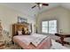 Cozy bedroom featuring a large bed with decorative pillows, a ceiling fan and a window at 2123 Floral Ridge Dr, Dacula, GA 30019