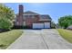 Brick home featuring a three car garage and a long driveway with well manicured landscaping at 2123 Floral Ridge Dr, Dacula, GA 30019