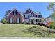 Attractive two-story brick home with manicured lawn and covered front porch at 2123 Floral Ridge Dr, Dacula, GA 30019