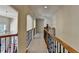 A long hallway with arched entryways, hardwood railings, and wrought iron balusters on the second floor at 2123 Floral Ridge Dr, Dacula, GA 30019