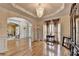 Elegant living room with hardwood floors, chandelier, and arched doorway to a dining area at 2123 Floral Ridge Dr, Dacula, GA 30019
