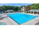 Community pool featuring a large deck with covered bar, lounge chairs, and lush trees at 2123 Floral Ridge Dr, Dacula, GA 30019