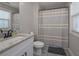 Bright bathroom with granite countertop vanity and shower with neutral striped curtain at 7751 Capps Ridge Ln, Douglasville, GA 30135
