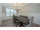 Formal dining room illuminated by a modern chandelier and complemented by wainscoting at 7751 Capps Ridge Ln, Douglasville, GA 30135