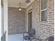Cozy front porch with brick columns, ambient lighting, and comfortable seating at 7751 Capps Ridge Ln, Douglasville, GA 30135