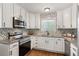 Contemporary kitchen with stainless steel appliances, granite countertops, and chic white cabinetry at 974 Shirley Se St, Smyrna, GA 30082