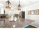 Beautiful kitchen with a large granite island, white cabinets, pendant lights, and herringbone backsplash at 974 Shirley Se St, Smyrna, GA 30082