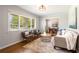 Sunlit living room features hardwood floors, neutral decor, and a view into the dining room at 974 Shirley Se St, Smyrna, GA 30082