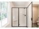 Modern bathroom featuring glass enclosed shower with black trim and hardware, and window with natural light at 1616 Ruskin Way, Marietta, GA 30062