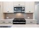 Modern kitchen features white cabinets, a stainless steel microwave, and a gas range at 1616 Ruskin Way, Marietta, GA 30062