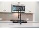 The kitchen features white cabinets, stainless steel microwave, and modern faucet at 1616 Ruskin Way, Marietta, GA 30062