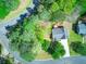 Aerial view of a home in a wooded lot and quiet neighborhood with a curved street at 501 Woodland Trce, Woodstock, GA 30189