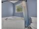Relaxing bathroom features corner soaking tub with shower curtain and window at 501 Woodland Trce, Woodstock, GA 30189