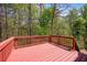 Red wooden deck offering views of the surrounding nature and trees at 501 Woodland Trce, Woodstock, GA 30189