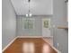 Dining area featuring wood floors, neutral paint, a modern light fixture, and a window overlooking the yard at 501 Woodland Trce, Woodstock, GA 30189