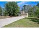 Suburban two-story home with a long drive and two-car garage, surrounded by trees and lush green lawns at 501 Woodland Trce, Woodstock, GA 30189