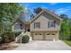 Inviting two-story home with a well-maintained front yard and two-car garage and mature trees on a sunny day at 501 Woodland Trce, Woodstock, GA 30189