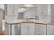 Bright kitchen showcases white cabinets, laminate countertops, stainless steel appliances, and views to another room at 501 Woodland Trce, Woodstock, GA 30189