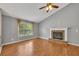 Spacious living room featuring a brick fireplace, wood floors, and abundant natural light from a large window at 501 Woodland Trce, Woodstock, GA 30189