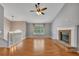 Sunlit living room features wood flooring, fireplace, and ceiling fan providing a comfortable and bright living space at 501 Woodland Trce, Woodstock, GA 30189