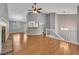 Open-concept living space with fireplace, staircase, and breakfast bar, all enhanced by beautiful wood flooring at 501 Woodland Trce, Woodstock, GA 30189