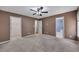 Spacious main bedroom with neutral carpet, ceiling fan, and doorways to an en-suite and walk-in closet at 501 Woodland Trce, Woodstock, GA 30189