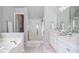 Bright bathroom featuring double vanity, enclosed shower, and soaking tub at 521 Mirramont Pl, Woodstock, GA 30189