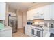 Bright kitchen featuring stainless steel appliances, white cabinets, and tiled floors for a modern and clean aesthetic at 521 Mirramont Pl, Woodstock, GA 30189