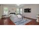 Cozy living room featuring a fireplace, large television, and comfortable seating on beautiful, stained hardwood floors at 521 Mirramont Pl, Woodstock, GA 30189