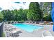Enjoy the community pool with lounge chairs and tables, surrounded by mature trees at 521 Mirramont Pl, Woodstock, GA 30189