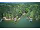 Aerial view shows the lake and docks around the houses in the woods at 934 Pine Cir, Woodstock, GA 30189