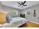 Cozy bedroom features hardwood floors, a ceiling fan, and windows with natural light at 934 Pine Cir, Woodstock, GA 30189
