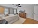 Bright bedroom features hardwood floors, ceiling fan, and flatscreen TV on wood dresser at 934 Pine Cir, Woodstock, GA 30189