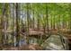 Picturesque view of wooden bridge crossing small stream leading to waterfront property at 934 Pine Cir, Woodstock, GA 30189