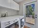 Functional laundry room with a washer, dryer, cabinets, and access to a deck at 934 Pine Cir, Woodstock, GA 30189