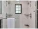 Luxurious walk-in shower featuring dual shower heads, tiled walls, and a glass block window at 934 Pine Cir, Woodstock, GA 30189
