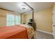 Bedroom featuring neutral color walls and carpet, with a four poster bed and view of the wooded outdoors at 1745 Mary Lou Ln, Atlanta, GA 30316