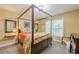 Bedroom featuring neutral color walls and carpet, with a four poster bed and view of the wooded outdoors at 1745 Mary Lou Ln, Atlanta, GA 30316
