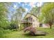 Charming two-story home with light yellow siding, a screened porch, a lawn and a small tree at 1745 Mary Lou Ln, Atlanta, GA 30316