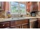 Close-up of the kitchen sink, featuring granite countertops, tile backsplash, and stainless steel appliances at 1745 Mary Lou Ln, Atlanta, GA 30316