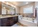 Main bathroom with a soaking tub, double vanity, and decorative tile backsplash at 1745 Mary Lou Ln, Atlanta, GA 30316