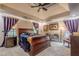 Spacious main bedroom featuring a tray ceiling, ceiling fan, plush carpet, and unique furniture at 1745 Mary Lou Ln, Atlanta, GA 30316