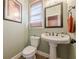 Charming powder room with a pedestal sink, toilet, and decorative mirror at 1745 Mary Lou Ln, Atlanta, GA 30316