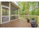 View of a screened porch with wood flooring and railing that overlooks the surrounding woods and greenery at 1745 Mary Lou Ln, Atlanta, GA 30316