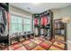 A large walk-in closet with custom shelves, shoe storage, colorful patterned rug, and view to the outside at 1745 Mary Lou Ln, Atlanta, GA 30316