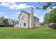 View of the home's backyard with a lawn, tall chimney, and a fenced perimeter at 2550 Columbia Crossing Ct, Decatur, GA 30034